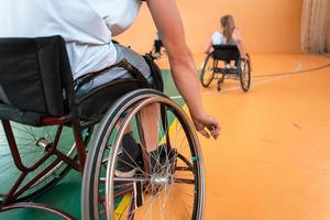 Nahaufnahme von Rollstühlen und behinderten Kriegsveteranen, die auf dem Platz Basketball spielen foto