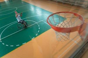 Abschleppfoto eines Kriegsveteranen, der Basketball in einer modernen Sportarena spielt. das Konzept des Sports für Menschen mit Behinderungen foto