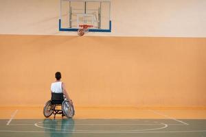 ein Foto eines Kriegsveteranen, der mit einem Team in einer modernen Sportarena Basketball spielt. das Konzept des Sports für Menschen mit Behinderungen