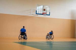 Training der Basketballmannschaft der Kriegsversehrten mit professionellen Sportgeräten für Menschen mit Behinderungen auf dem Basketballplatz foto