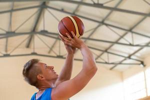 ein kriegsbeschädigter im rollstuhl trainiert mit einem ball in einem basketballverein beim training mit professionellen sportgeräten für behinderte. das Konzept des Sports für Menschen mit Behinderungen foto