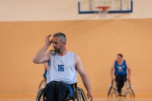 ein Foto eines Kriegsveteranen, der mit einem Team in einer modernen Sportarena Basketball spielt. das Konzept des Sports für Menschen mit Behinderungen