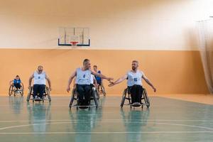ein Team von Kriegsveteranen in Rollstühlen, die Basketball spielen und die in einem Spiel gewonnenen Punkte feiern. High-Five-Konzept foto