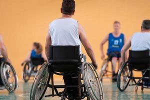 Nahaufnahme von Rollstühlen und behinderten Kriegsveteranen, die auf dem Platz Basketball spielen foto