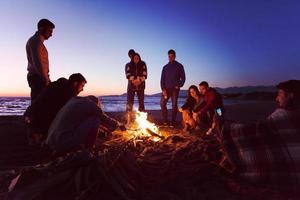 freunde, die sich am herbsttag am strand vergnügen foto