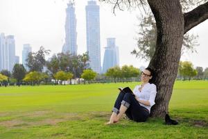 junge Frau, die ein Buch im Park liest foto