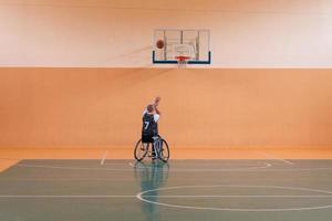 ein Foto eines Kriegsveteranen, der in einer modernen Sportarena Basketball spielt. das Konzept des Sports für Menschen mit Behinderungen