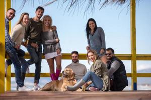 gruppe von freunden, die sich am herbsttag am strand amüsieren foto