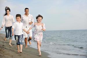 glückliche junge familie hat spaß am strand foto