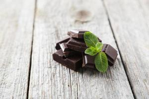 frische Minze mit Schokolade auf grauem hölzernem Hintergrund foto