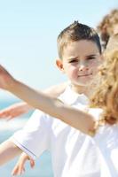 glückliche Kindergruppe, die am Strand spielt foto