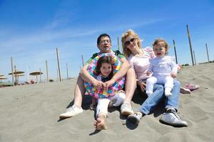 glückliche junge familie hat spaß am strand foto