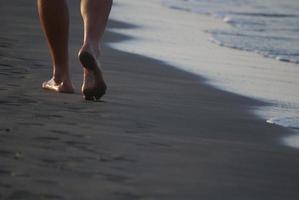 Mann, der am Strand spazieren geht foto