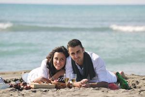 junges Paar beim Picknick am Strand foto