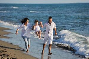 glückliche junge familie hat spaß am strand foto