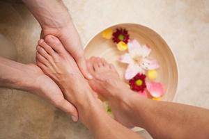 Fußpfleger waschen die Füße eines Kunden