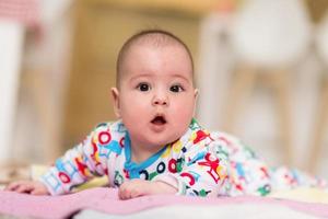 Neugeborenes Baby, das auf dem Boden spielt foto