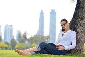 schöne junge Frau mit Tablet im Park foto