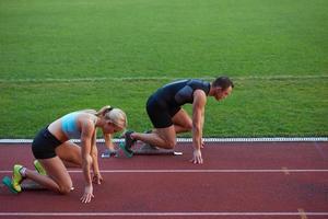 athletinnengruppe, die auf leichtathletik-rennstrecke läuft foto