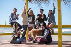 gruppe von freunden, die sich am herbsttag am strand amüsieren foto