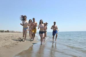 Happy People Group hat Spaß und läuft am Strand foto