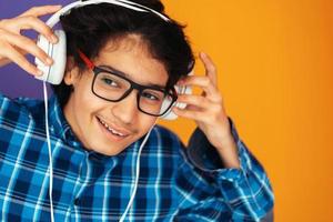 Teenager mit Kopfhörern und Musik hören lila Hintergrund foto