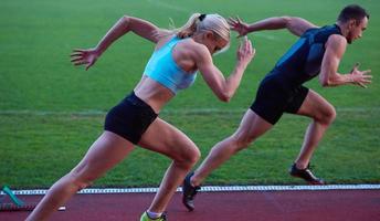 Frauengruppe, die von Anfang an auf der Leichtathletik-Rennstrecke läuft foto