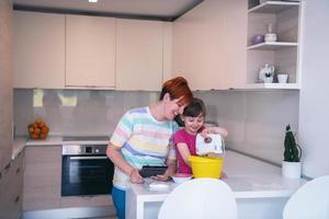 kleines mädchen und mutter machen tastz kuchen in der kithen familie und haben spaß zu hause foto