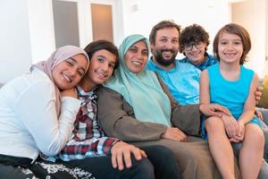 Porträtfoto einer arabischen muslimischen Familie, die auf einer Couch im Wohnzimmer eines großen modernen Hauses sitzt. selektiver Fokus foto