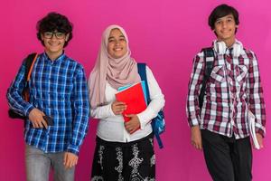 eine gruppe arabischer teenager, ein studententeam, das in die zukunft und zurück zur schule geht, das konzept eines rosa hintergrunds. das Konzept einer erfolgreichen Bildung für junge Menschen. selektiver Fokus foto