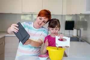 kleines mädchen und mutter machen tastz kuchen in der kithen familie und haben spaß zu hause foto