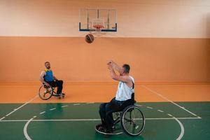 Behinderte Kriegsveteranen im Einsatz beim Basketballspielen auf einem Basketballplatz mit professioneller Sportausrüstung für Behinderte foto