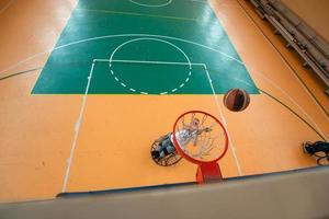 Abschleppfoto eines Kriegsveteranen, der Basketball in einer modernen Sportarena spielt. das Konzept des Sports für Menschen mit Behinderungen foto