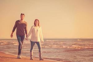 Liebendes junges Paar an einem Strand am sonnigen Herbsttag foto