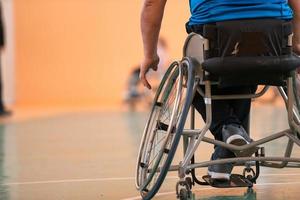 Nahaufnahme von Rollstühlen und behinderten Kriegsveteranen, die auf dem Platz Basketball spielen foto