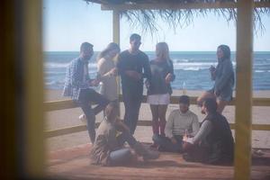 gruppe von freunden, die sich am herbsttag am strand amüsieren foto