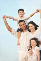 glückliche junge familie hat spaß am strand foto