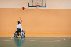 ein Foto eines Kriegsveteranen, der mit einem Team in einer modernen Sportarena Basketball spielt. das Konzept des Sports für Menschen mit Behinderungen