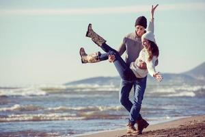 Liebendes junges Paar an einem Strand am sonnigen Herbsttag foto