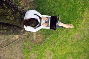 Frau mit Laptop im Park foto