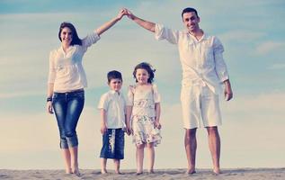 Familie am Strand mit Heimzeichen foto