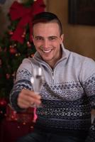 glücklicher junger Mann mit einem Glas Champagner foto