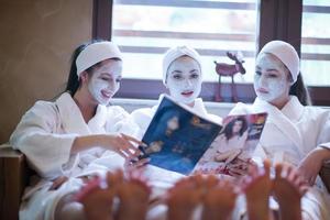 junggesellenabschied im spa, mädchen mit gesichtsmaske lesen zeitschrift foto