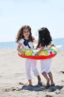 glückliche Kindergruppe, die am Strand spielt foto