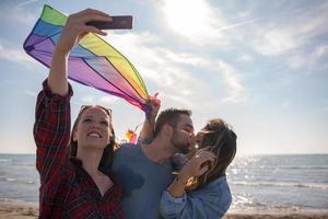 gruppe von freunden, die während des herbsttages selfie am strand machen foto