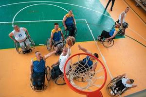 ein Foto von Basketballmannschaften mit Behinderungen mit dem Auswähler in der großen Halle vor Beginn des Basketballspiels
