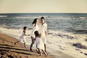 glückliche junge familie hat spaß am strand foto