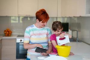 kleines mädchen und mutter machen tastz kuchen in der kithen familie und haben spaß zu hause foto