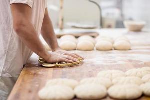 Bäckereiarbeiter, der den Teig zubereitet foto