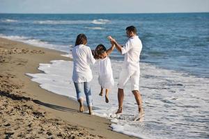 glückliche junge familie hat spaß am strand foto